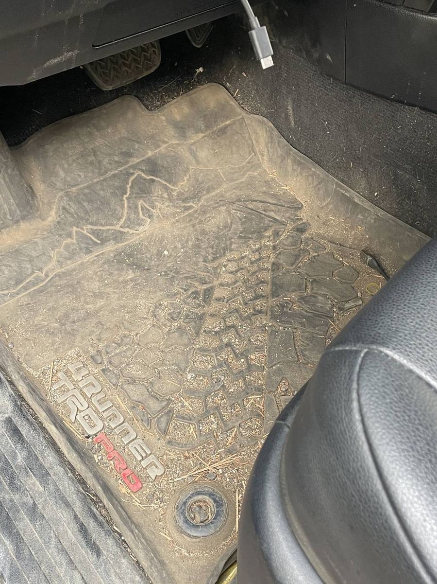 Toyota 4Runner TRD Pro driver floor mat before detailing — caked in dried mud, the tread pattern completely filled in