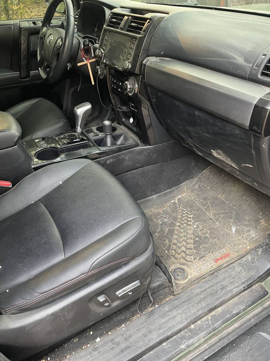 Toyota 4Runner TRD Pro front cabin before detailing — trail dust settled across the dash, vents and door card