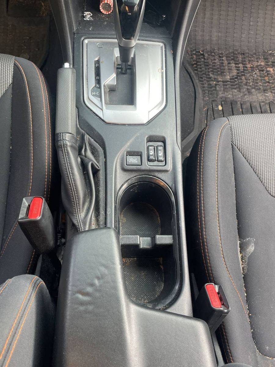 Subaru Crosstrek center console before detailing — grime in the cup holders and around the shifter