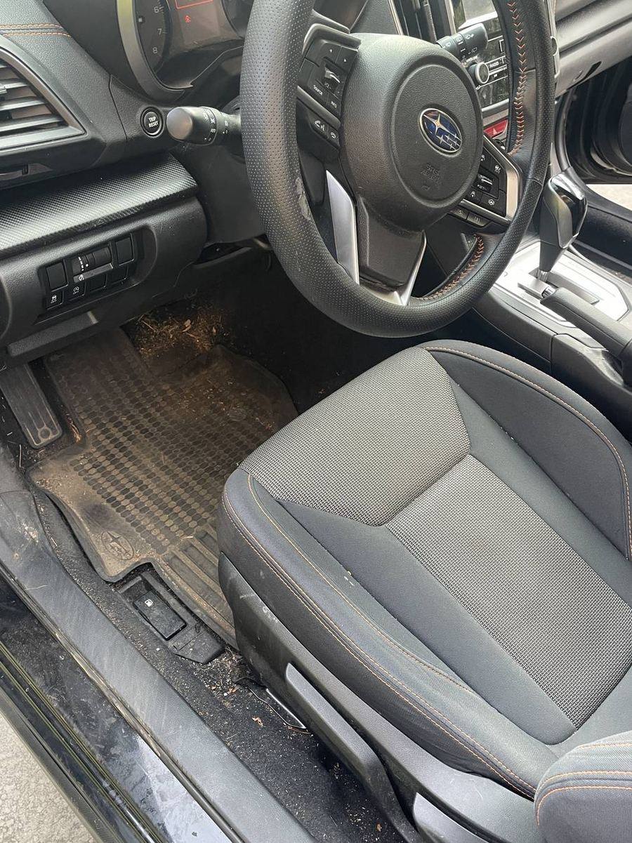 Subaru Crosstrek driver's side before detailing — dirt tracked along the sill and carpet edge