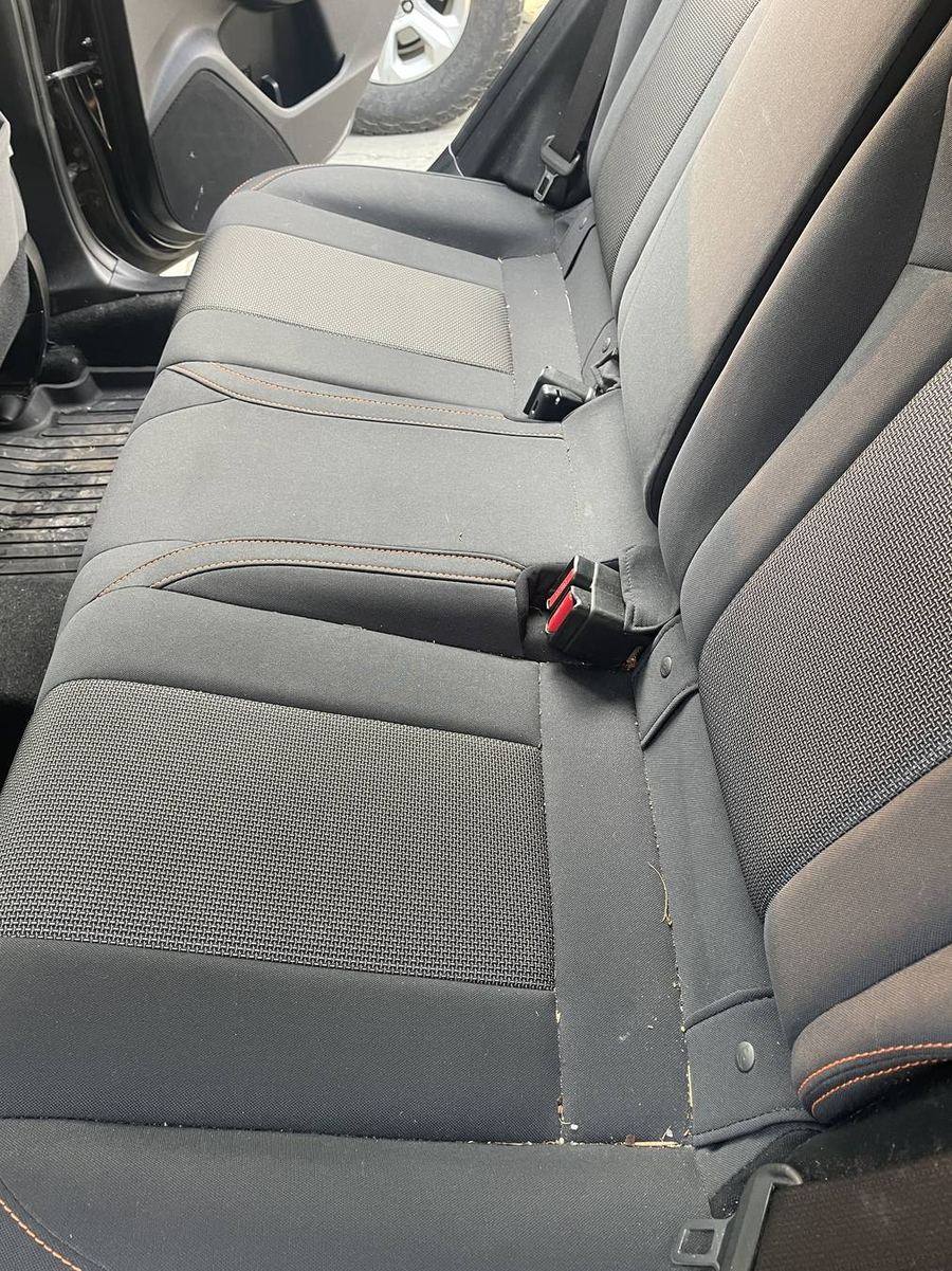 Subaru Crosstrek rear bench before detailing — crumbs and grit worked into the seams