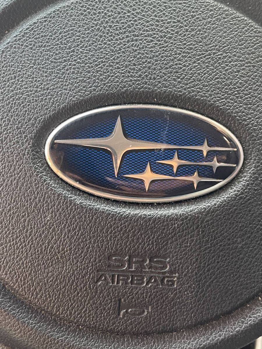 Subaru Crosstrek steering wheel before detailing — dust settled in the grain and lettering